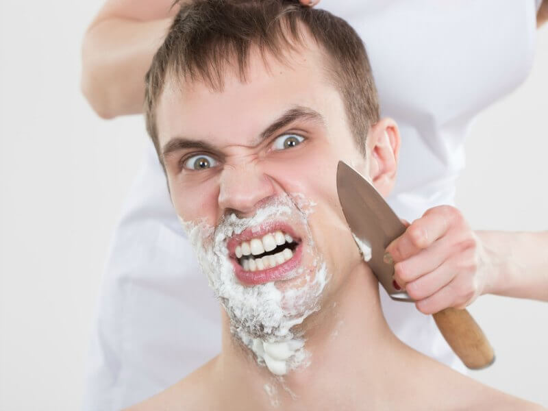 handsome man shaves a woman with a knife