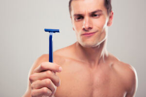 man looking disgusted at disposable razor