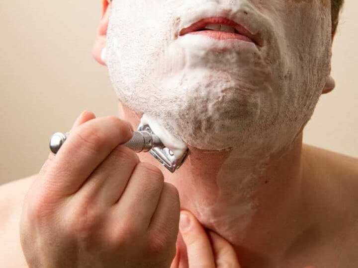 man shaving neck skin with double edge razor