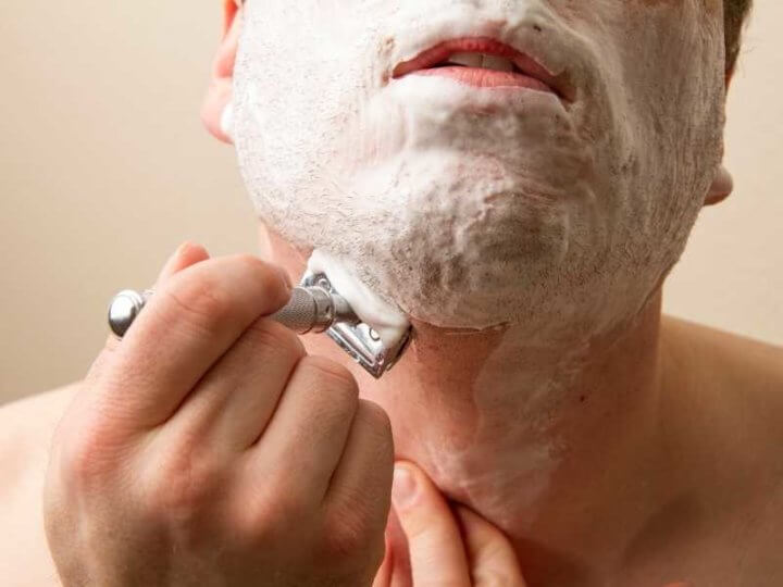 man shaving with double edge razor