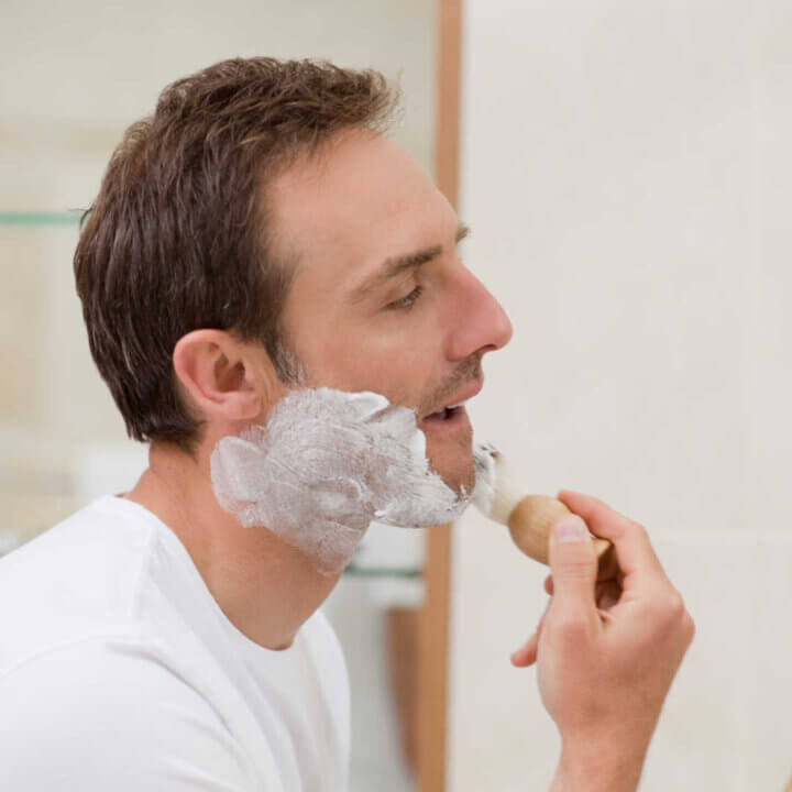 man shaving in bathroom