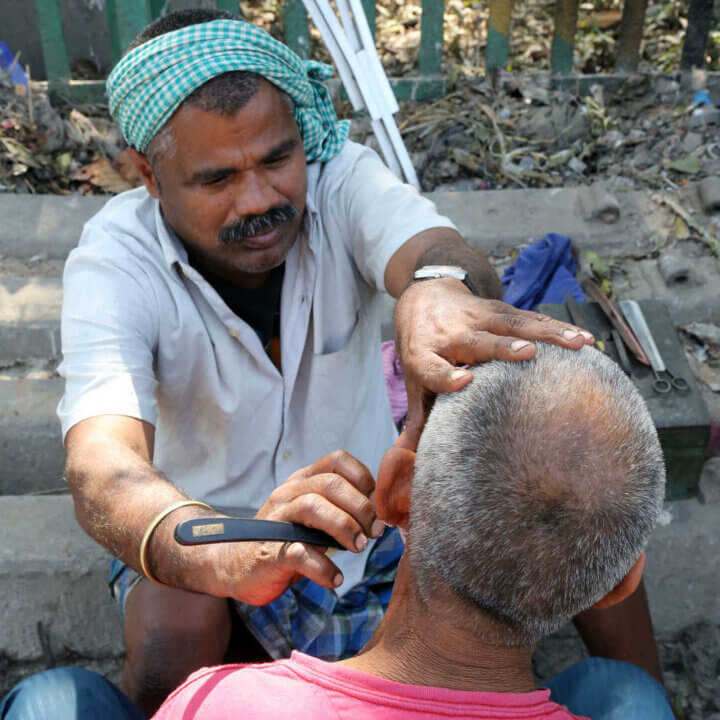 street barber shaving customer face