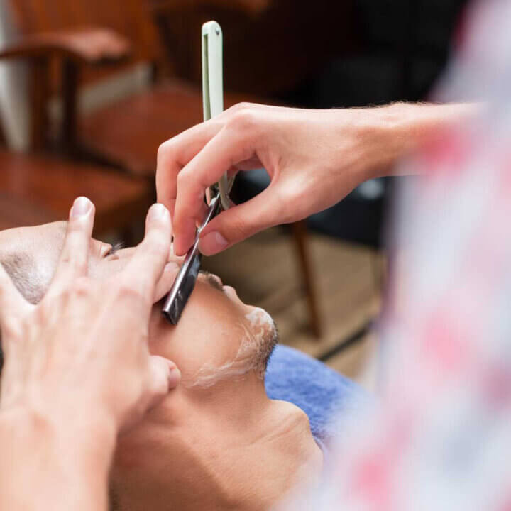barber shaving customers face