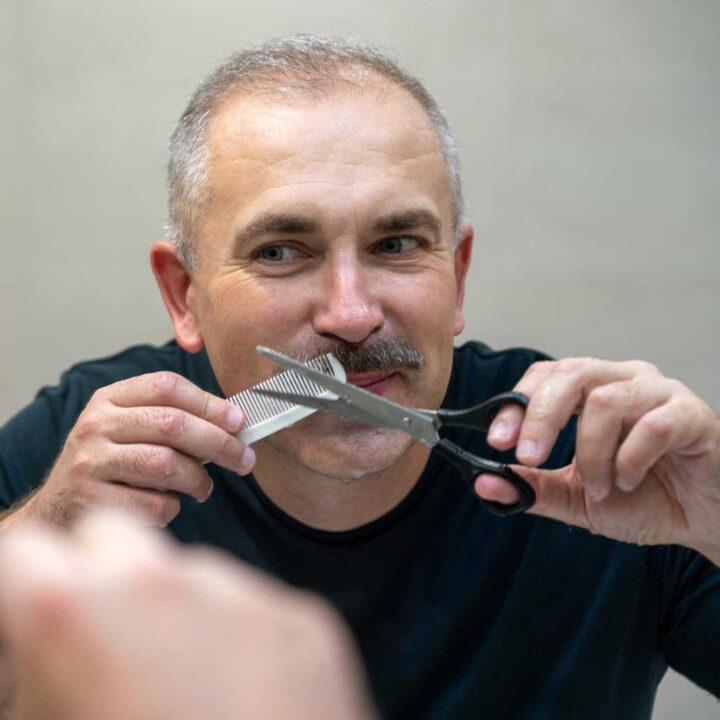 man trimming mustache