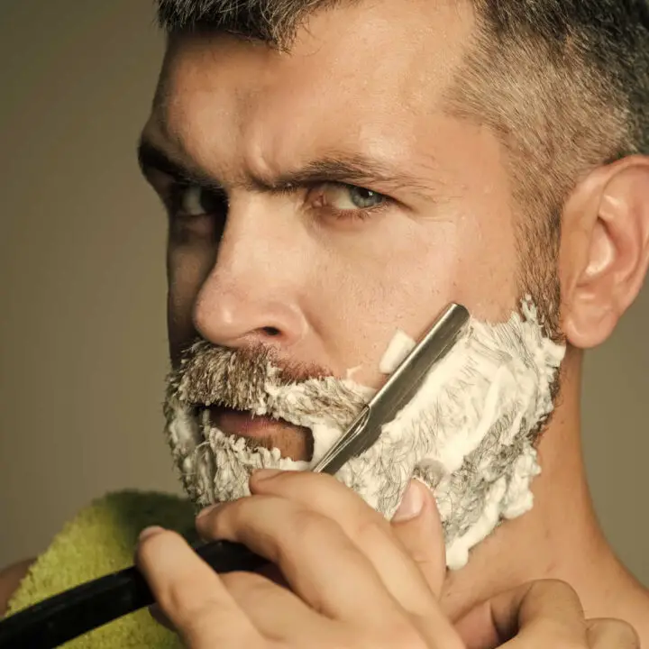 man shaving with straight razor