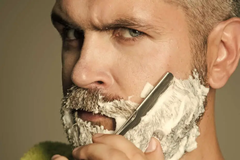 man shaving with straight razor