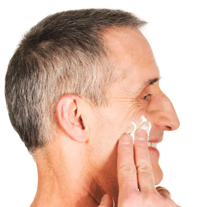 man applying lotion to face