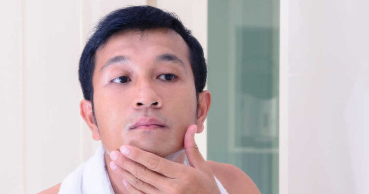 man applying product to face
