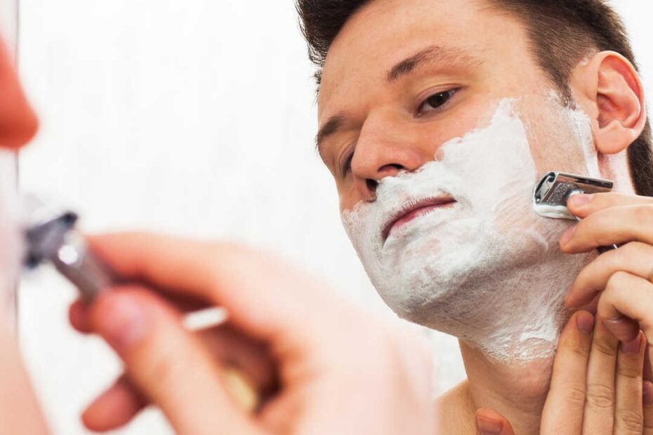 man shaving with double edge razor