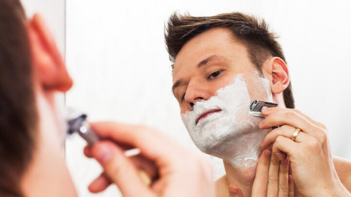 man shaving with double edge razor