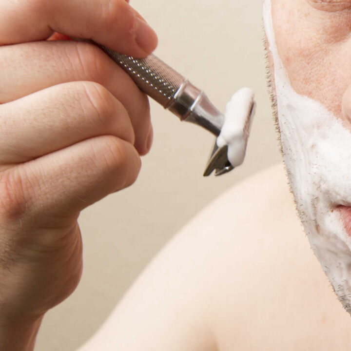 closeup razor near lathered face